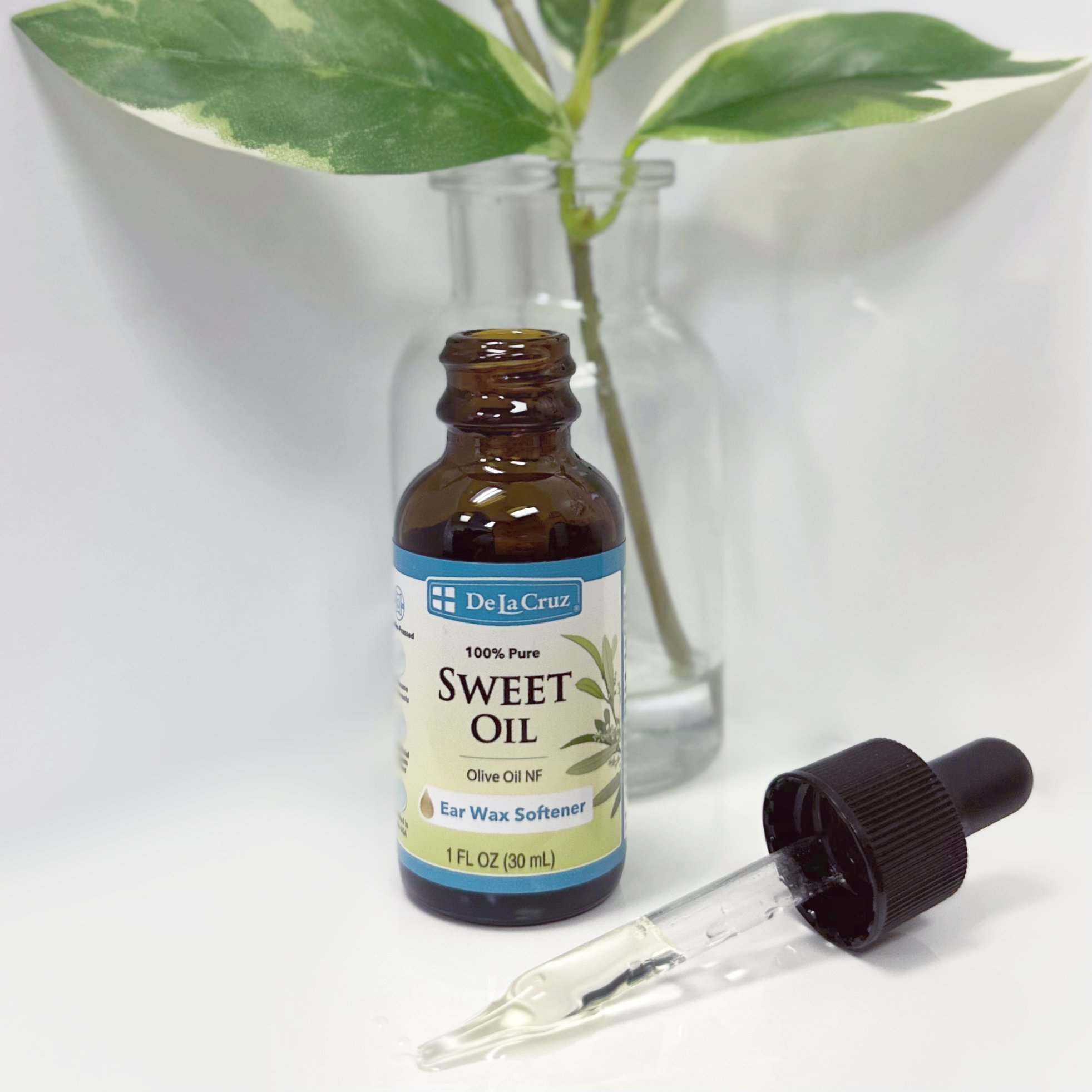 Bottle of De La Cruz Sweet Oil with dropper on a white background