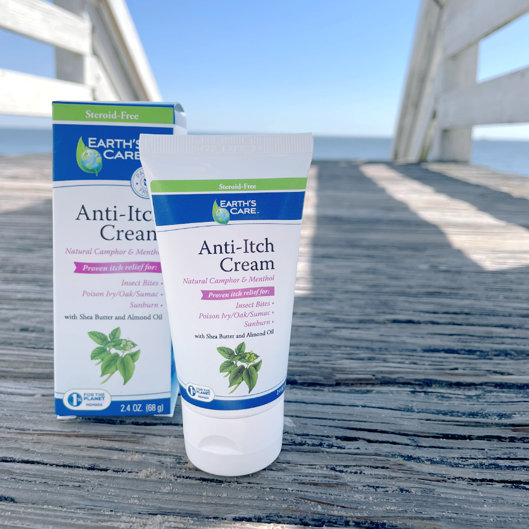 Earth's Care Anti-Itch Cream tube and matching box displayed on a weathered wooden dock with the ocean and sky blurred in the background.