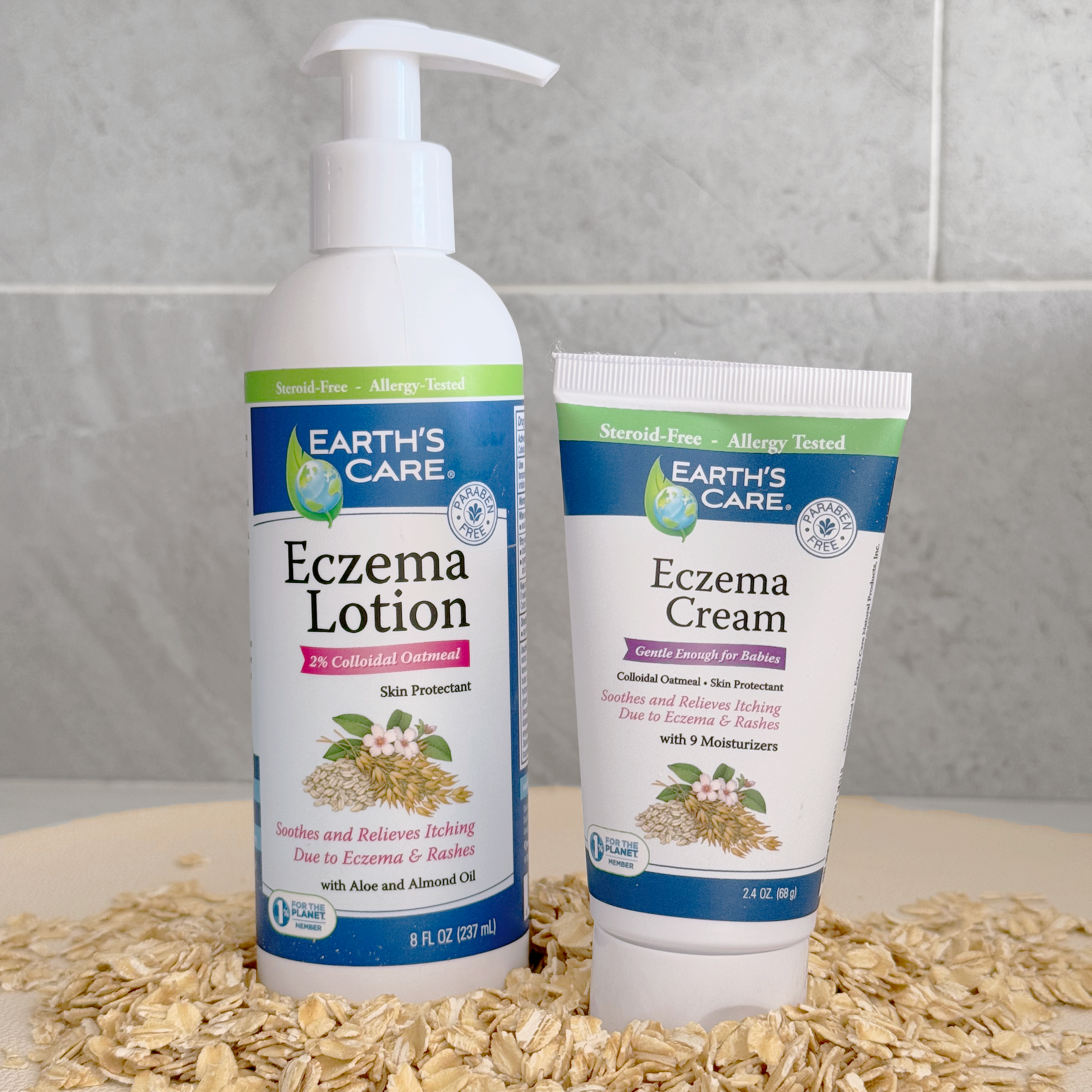 Earth's Care Eczema Lotion pump bottle and Eczema Cream tube standing on a bed of rolled oats against a gray tiled background.
