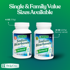 Two bottles of De La Cruz Sodium Bicarbonate Antacid on a green background with text about size options.
